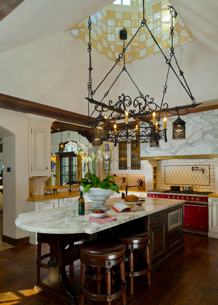 Inspiration for a large mediterranean u-shaped separate kitchen in San Francisco with marble benchtops, coloured appliances, an undermount sink, raised-panel cabinets, dark wood cabinets, grey splashback, subway tile splashback, dark hardwood floors, with island, brown floor and grey benchtop.