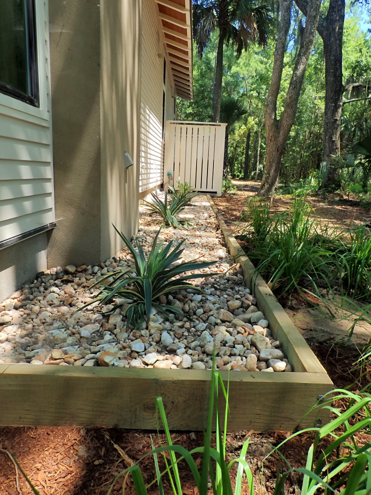 This is an example of a contemporary side yard partial sun garden in Other with with lawn edging and river rock.
