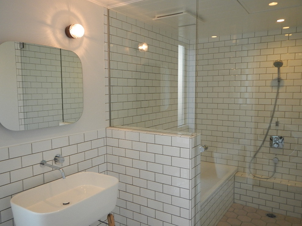 Photo of a modern bathroom in Other with white tile and subway tile.