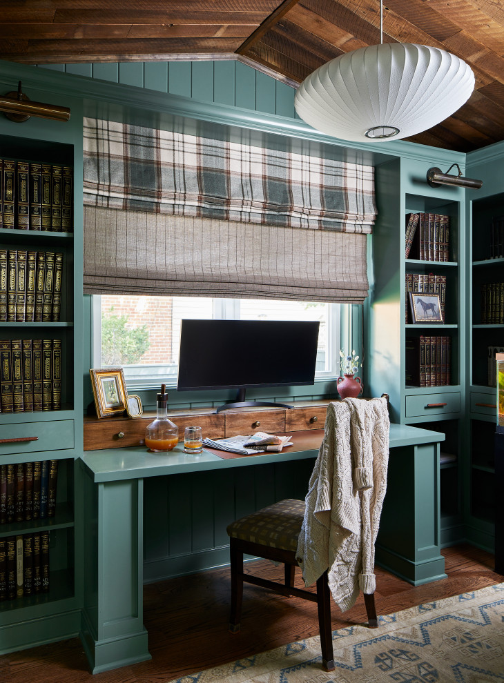 Photo of a transitional home office in Baltimore with blue walls, dark hardwood floors, a built-in desk, brown floor, vaulted and wood.