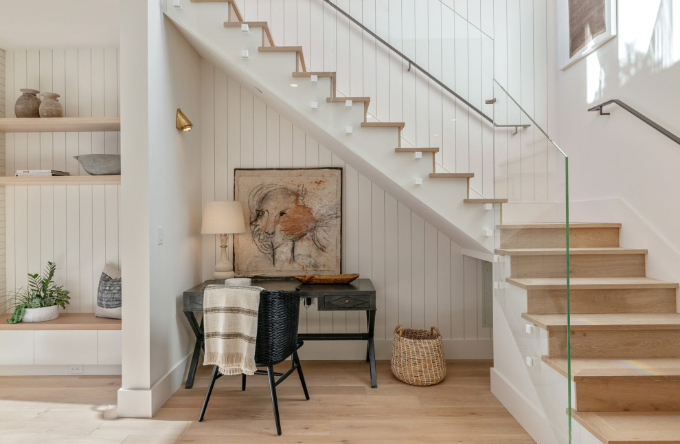 Photo of a transitional wood l-shaped staircase in San Francisco with wood risers, glass railing and panelled walls.