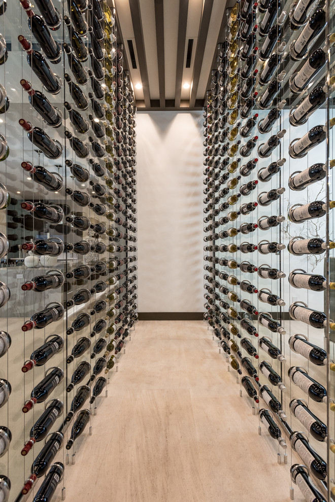 Photo of a large contemporary wine cellar in Las Vegas with limestone floors, display racks and beige floor.