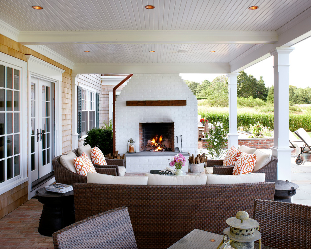 Inspiration for a mid-sized beach style backyard patio in Boston with a fire feature, brick pavers and a roof extension.