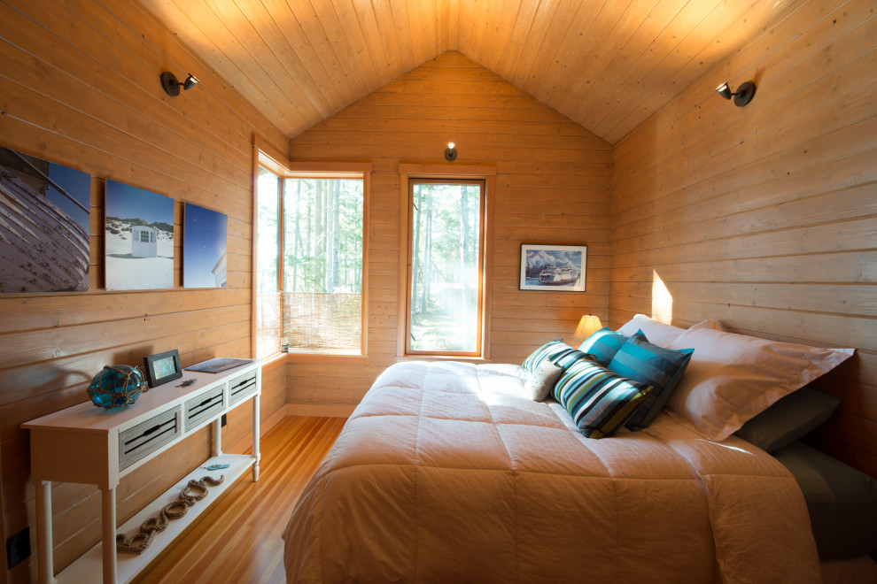 Foto de dormitorio principal costero con suelo de madera en tonos medios, vigas vistas y panelado