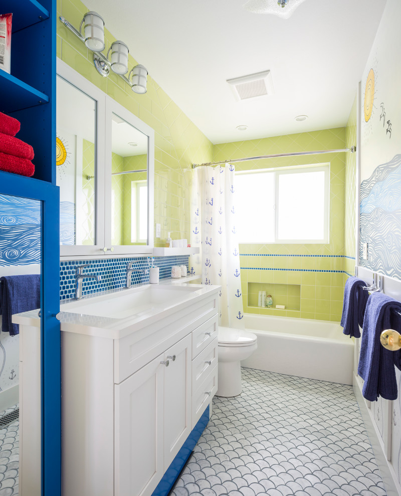 Photo of a mid-sized beach style kids bathroom in Seattle with white cabinets, a shower/bathtub combo, marble floors, quartzite benchtops, shaker cabinets, an alcove tub, blue tile, green tile, multi-coloured walls, an undermount sink and a shower curtain.