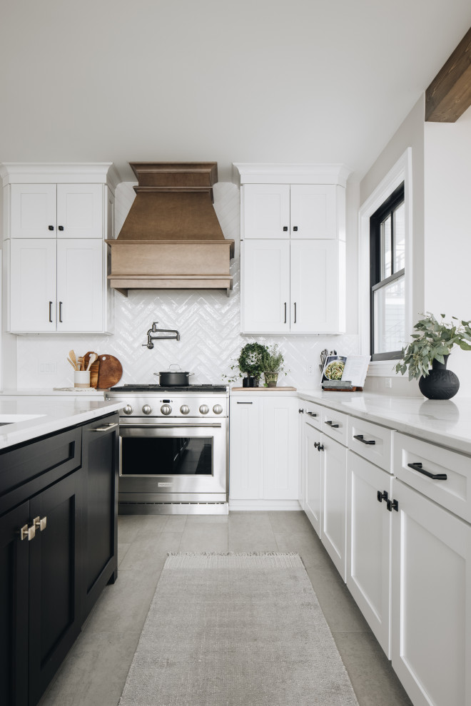 Design ideas for a large modern u-shaped open plan kitchen in Grand Rapids with an undermount sink, shaker cabinets, black cabinets, quartz benchtops, white splashback, ceramic splashback, stainless steel appliances, porcelain floors, with island, grey floor and white benchtop.