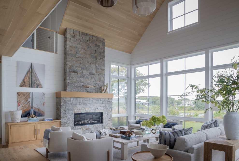 Beach style open concept living room in Boston with white walls, light hardwood floors, a ribbon fireplace, beige floor, vaulted, wood and planked wall panelling.