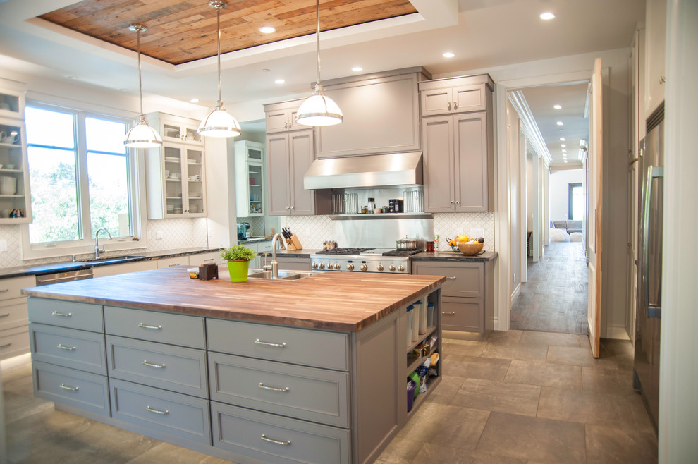 Inspiration for a large contemporary galley open plan kitchen in San Francisco with an undermount sink, beaded inset cabinets, grey cabinets, wood benchtops, white splashback, stainless steel appliances, with island and ceramic floors.