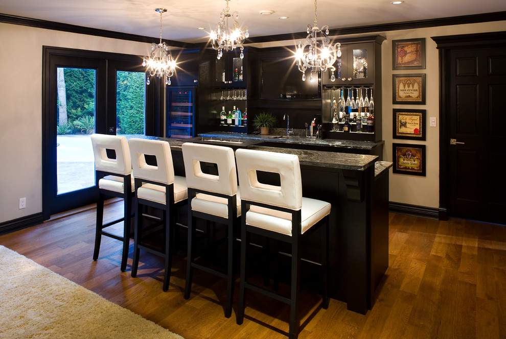 Transitional galley seated home bar in Vancouver with medium hardwood floors and black cabinets.