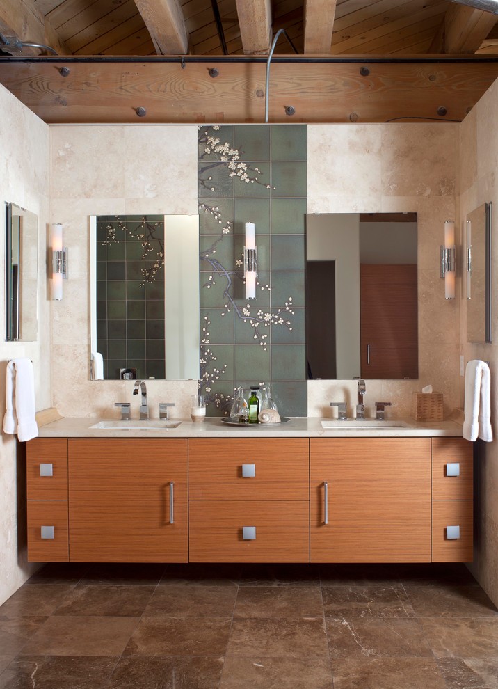 This is an example of a large contemporary master bathroom in Denver with an undermount sink, flat-panel cabinets, medium wood cabinets, marble benchtops, a wall-mount toilet, green tile, ceramic tile, beige walls, marble floors, a freestanding tub and beige benchtops.