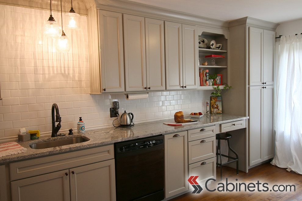 Inspiration for a transitional medium tone wood floor kitchen remodel in Tampa with a drop-in sink, flat-panel cabinets, gray cabinets, white backsplash, subway tile backsplash, stainless steel appliances and no island