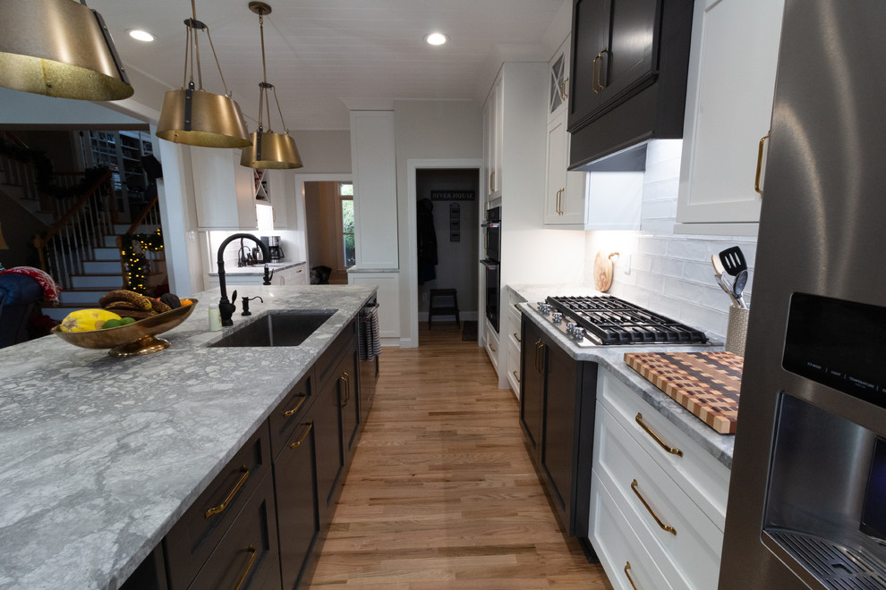 Example of a large l-shaped eat-in kitchen design with shaker cabinets, white cabinets, granite countertops, an island and white countertops