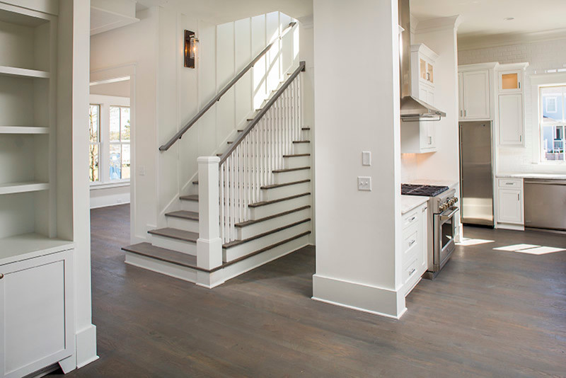 Mid-sized beach style wood l-shaped staircase in Charleston with painted wood risers.