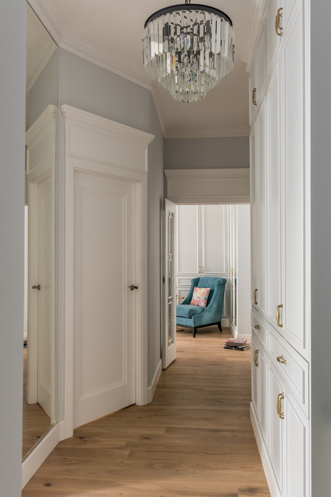 Photo of a transitional entry hall in Moscow with grey walls and light hardwood floors.
