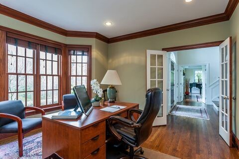 Mid-sized traditional home office in Bridgeport with green walls, laminate floors, a freestanding desk and brown floor.