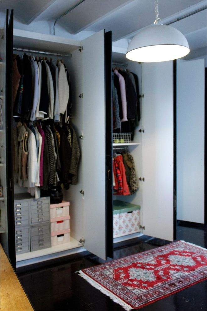 Design ideas for a small industrial gender-neutral built-in wardrobe in Barcelona with flat-panel cabinets and white cabinets.