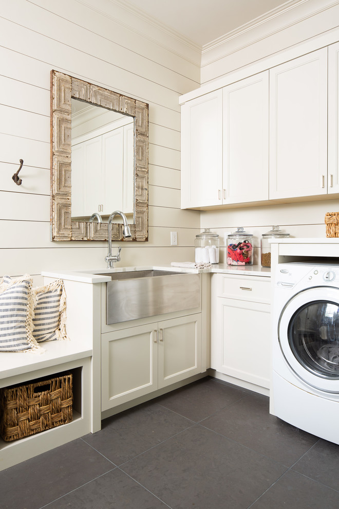 Mid-sized country l-shaped utility room in Atlanta with a farmhouse sink, recessed-panel cabinets, white cabinets, white walls, grey floor, white benchtop, quartz benchtops, concrete floors and a side-by-side washer and dryer.