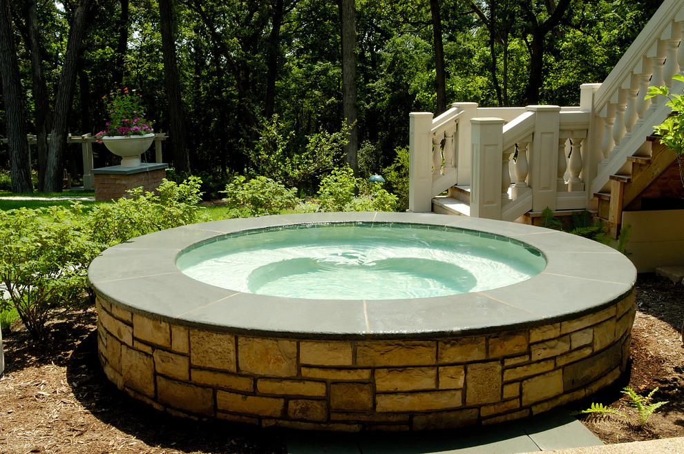 Inspiration for a small traditional backyard round pool in Chicago with a hot tub.