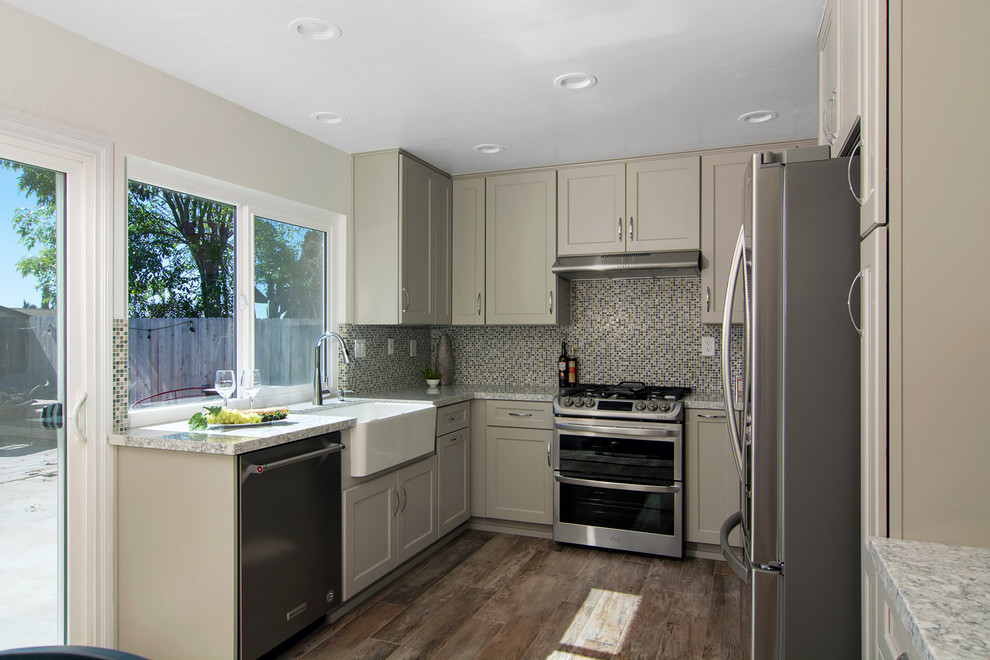 This is an example of a mid-sized transitional u-shaped eat-in kitchen in San Diego with a farmhouse sink, shaker cabinets, grey cabinets, quartz benchtops, multi-coloured splashback, mosaic tile splashback, stainless steel appliances, porcelain floors, no island, grey floor and multi-coloured benchtop.