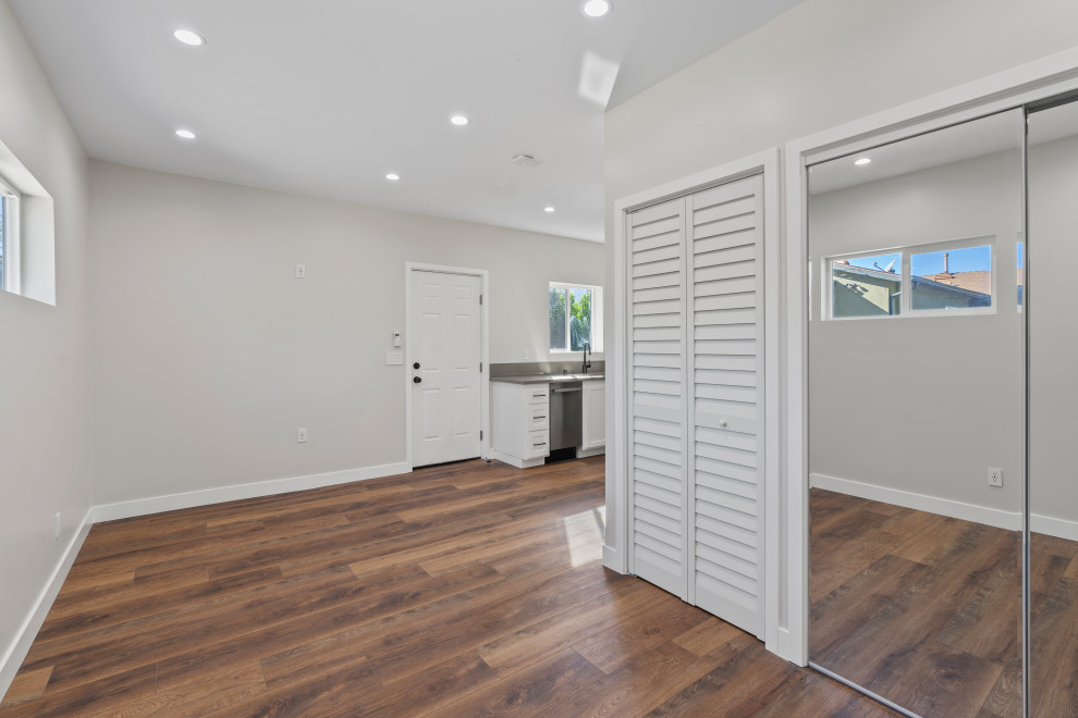 Idée de décoration pour une porte d'entrée minimaliste de taille moyenne avec un mur blanc, un sol en bois brun, une porte simple, une porte blanche, un sol marron, un plafond en papier peint et du papier peint.