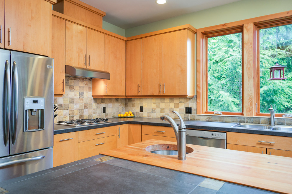 Contemporary kitchen in Seattle with an undermount sink, flat-panel cabinets, light wood cabinets, multi-coloured splashback, mosaic tile splashback and stainless steel appliances.