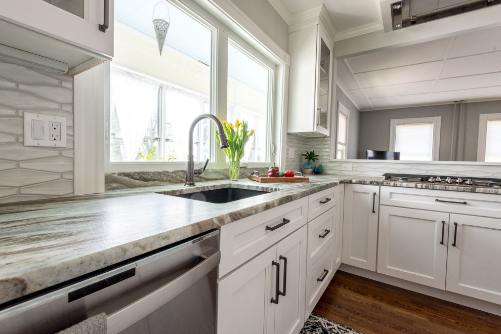 Example of a mid-sized transitional u-shaped medium tone wood floor and brown floor eat-in kitchen design in Boston with an undermount sink, shaker cabinets, white cabinets, quartzite countertops, gray backsplash, ceramic backsplash, stainless steel appliances, an island and multicolored countertops