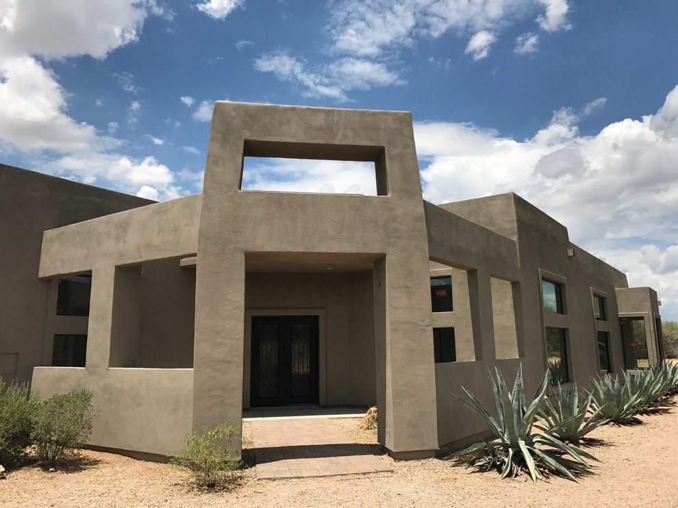 Expansive two-storey stucco brown house exterior in Phoenix with a flat roof.