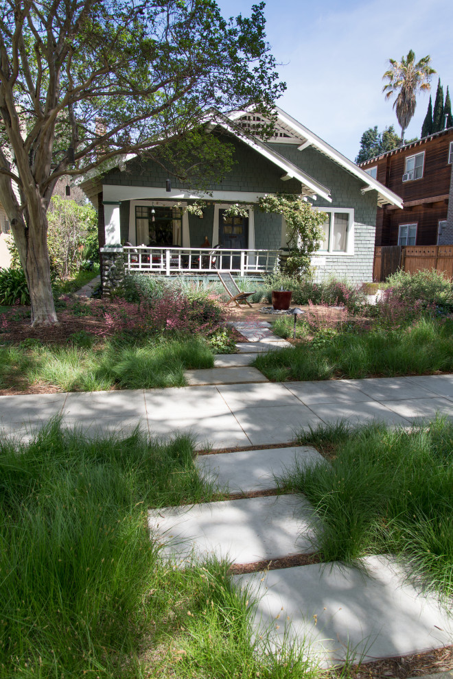 Small arts and crafts front yard partial sun xeriscape in Los Angeles with a garden path and concrete pavers for spring.