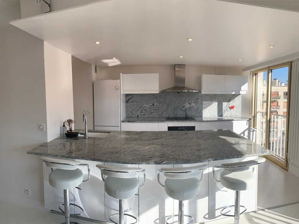 This is an example of a large mediterranean galley eat-in kitchen in Paris with an integrated sink, granite benchtops, grey splashback, with island and grey benchtop.
