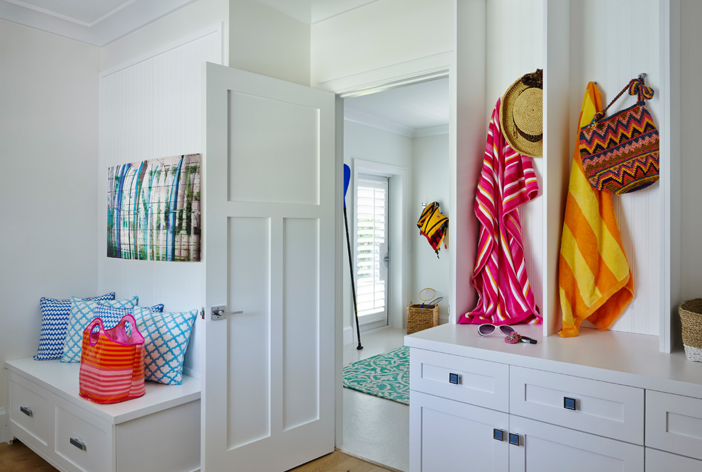 Mid-sized beach style mudroom in San Diego with medium hardwood floors and white walls.