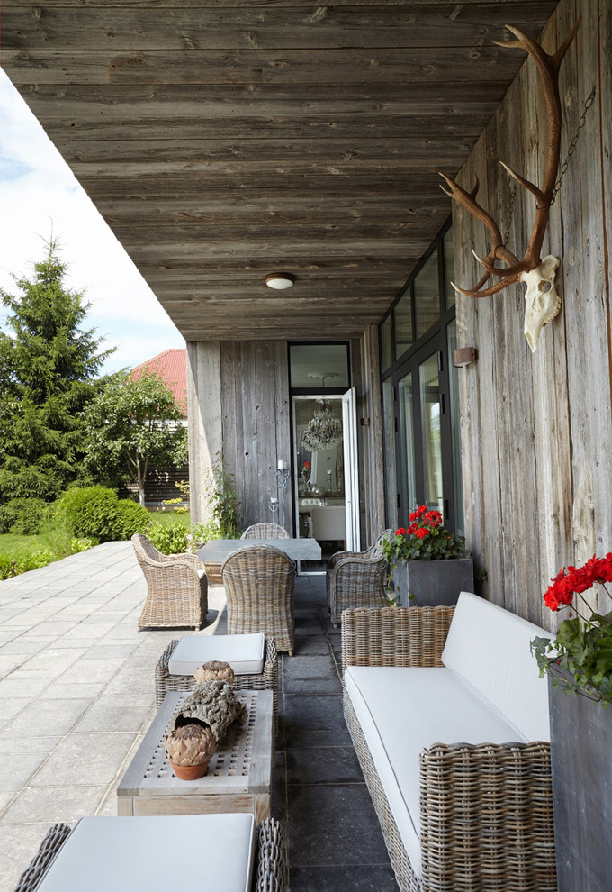 Country backyard verandah in Moscow with a roof extension.