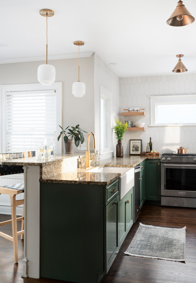 Inspiration for a mid-sized transitional l-shaped dark wood floor and brown floor open concept kitchen remodel in Chicago with a farmhouse sink, recessed-panel cabinets, green cabinets, granite countertops, white backsplash, ceramic backsplash, stainless steel appliances, a peninsula and beige countertops