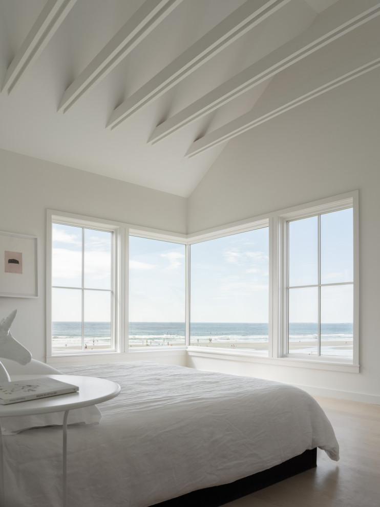 Photo of a scandi master bedroom in Portland Maine with white walls and exposed beams.