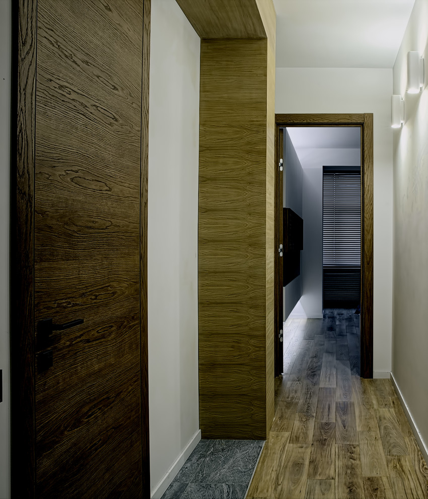Contemporary hallway in Moscow with white walls and medium hardwood floors.