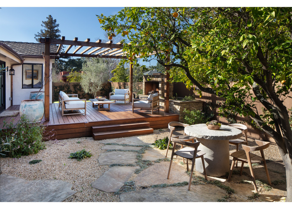 Diseño de jardín mediterráneo en patio trasero con chimenea, exposición parcial al sol, entablado y con madera