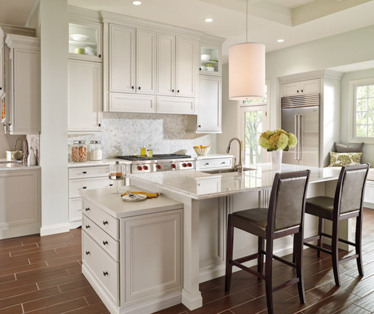 Inspiration for a mid-sized transitional l-shaped dark wood floor and brown floor eat-in kitchen remodel in Orange County with an undermount sink, recessed-panel cabinets, white cabinets, granite countertops, beige backsplash, ceramic backsplash, stainless steel appliances and an island
