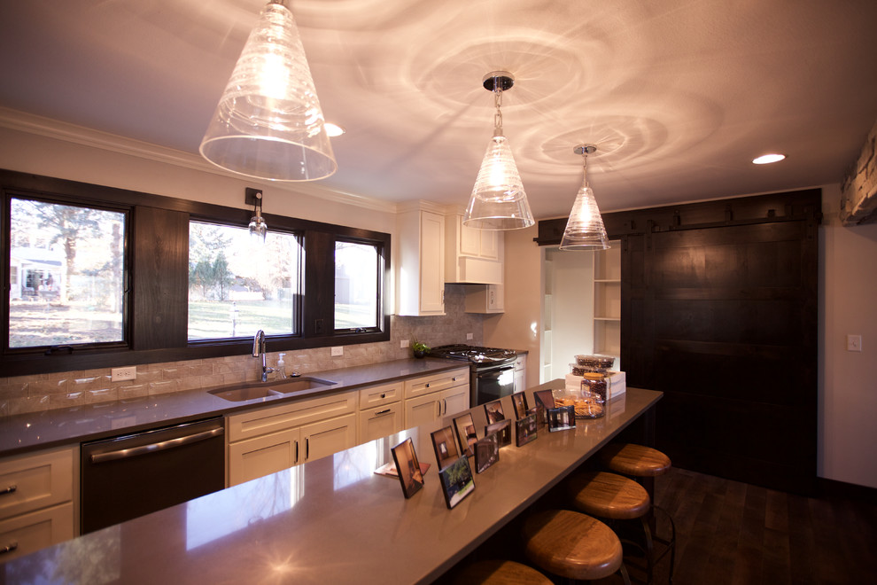 Large transitional galley dark wood floor kitchen pantry photo with an undermount sink, shaker cabinets, white cabinets, quartzite countertops, beige backsplash, glass tile backsplash and an island