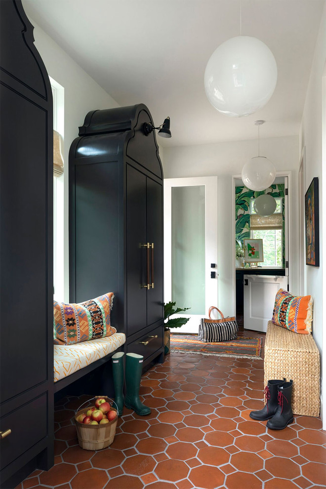 Design ideas for an eclectic mudroom in Minneapolis with white walls, terra-cotta floors, a glass front door and orange floor.