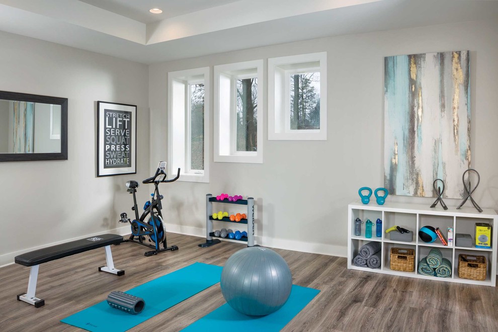This is an example of a mid-sized beach style home yoga studio in Other with vinyl floors, brown floor and grey walls.