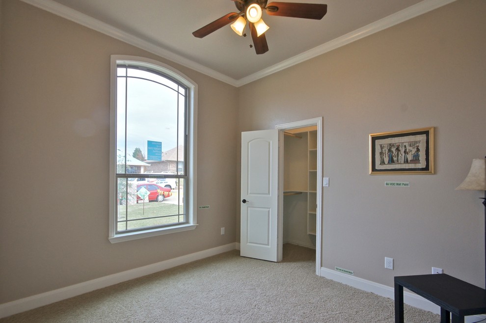 This is an example of a mid-sized traditional guest bedroom in Dallas with beige walls and carpet.