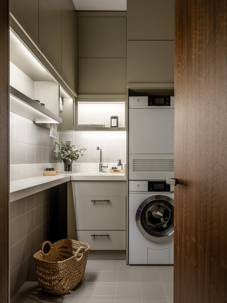 Foto di una lavanderia design con ante beige e lavatrice e asciugatrice a colonna