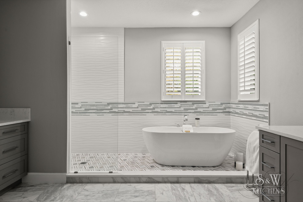 Example of a mid-sized minimalist master white tile and porcelain tile marble floor, white floor and double-sink bathroom design in Tampa with shaker cabinets, gray cabinets, gray walls, an undermount sink, quartz countertops, white countertops, a niche and a built-in vanity
