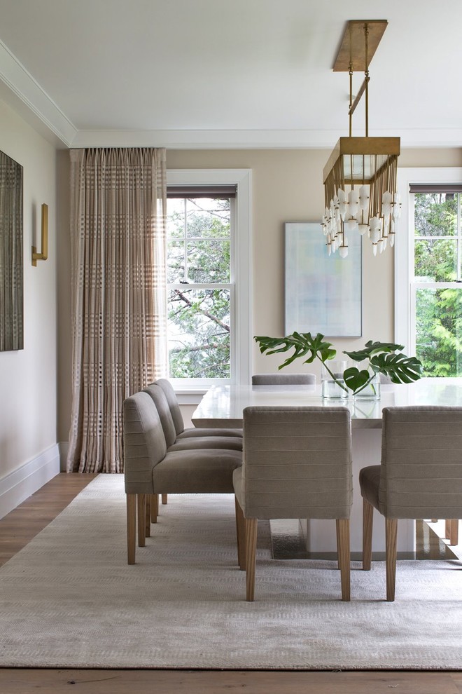 Example of a large transitional medium tone wood floor and brown floor dining room design with beige walls