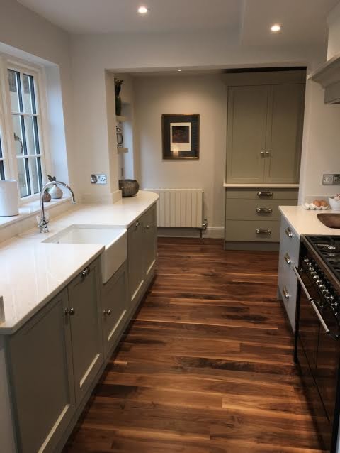 Design ideas for a small contemporary l-shaped separate kitchen in Surrey with a farmhouse sink, recessed-panel cabinets, white splashback, subway tile splashback, panelled appliances, medium hardwood floors and no island.