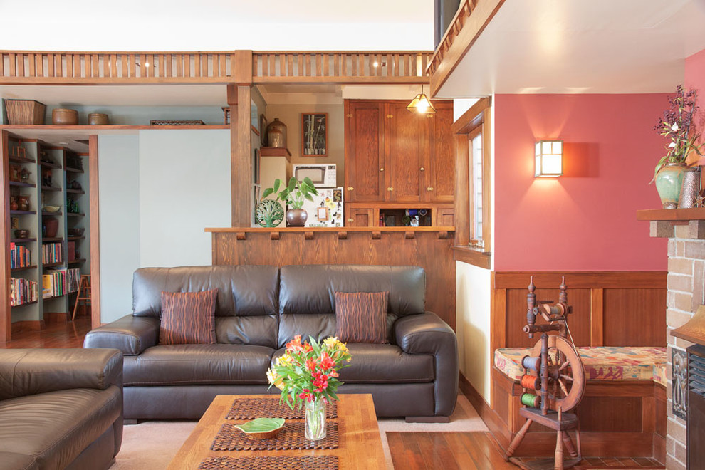 This is an example of a Mid-sized arts and crafts One-storey Open Concept living room in Auckland With a Library, Yellow Walls, Carpet, a Standard Fireplace, a Brick Fireplace Surround, a Wall-mounted TV and Brown Floor.