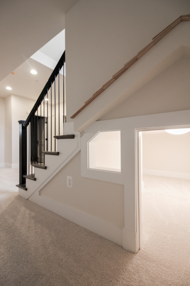 This is an example of a mid-sized contemporary wood u-shaped staircase in DC Metro with wood risers and metal railing.