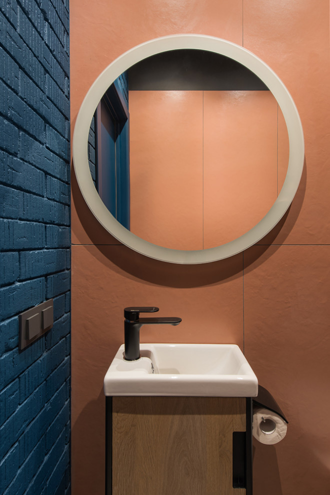 Свежая идея для дизайна: туалет среднего размера в стиле лофт с плоскими фасадами, темными деревянными фасадами, инсталляцией, оранжевой плиткой, керамогранитной плиткой, синими стенами, полом из керамогранита, подвесной раковиной, подвесной тумбой, кирпичными стенами и коричневым полом - отличное фото интерьера