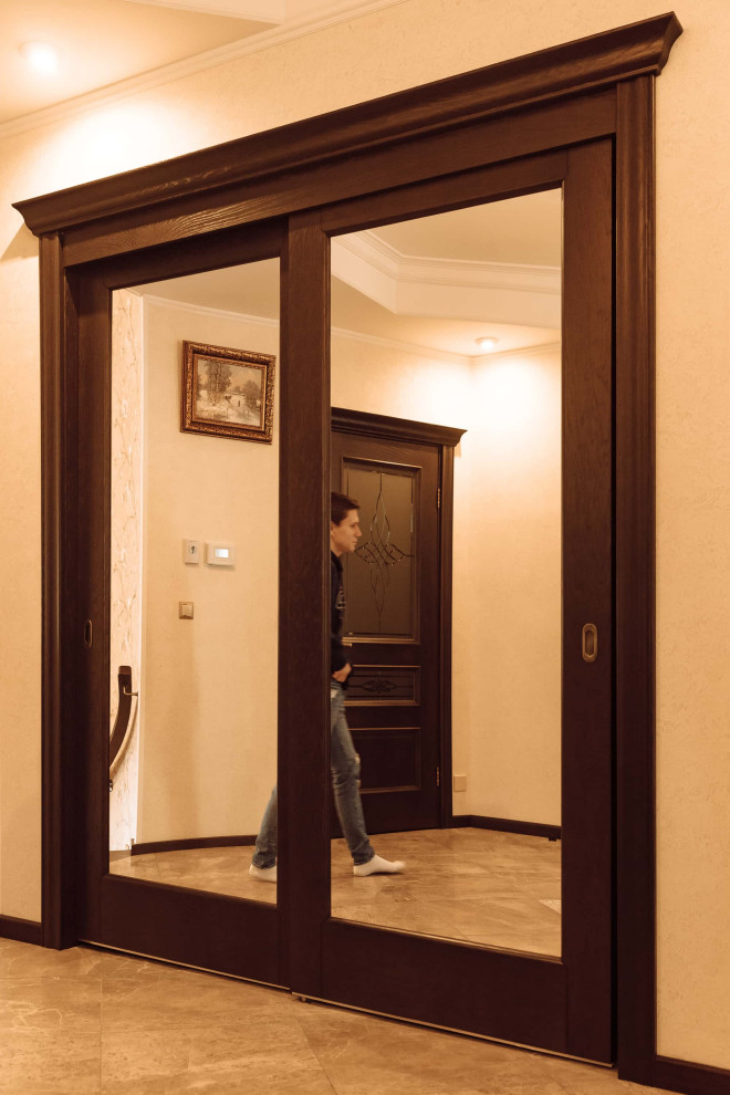 Mittelgroße Klassische Haustür mit beiger Wandfarbe, Keramikboden, Doppeltür, dunkler Holzhaustür, braunem Boden, Kassettendecke und Tapetenwänden in Moskau