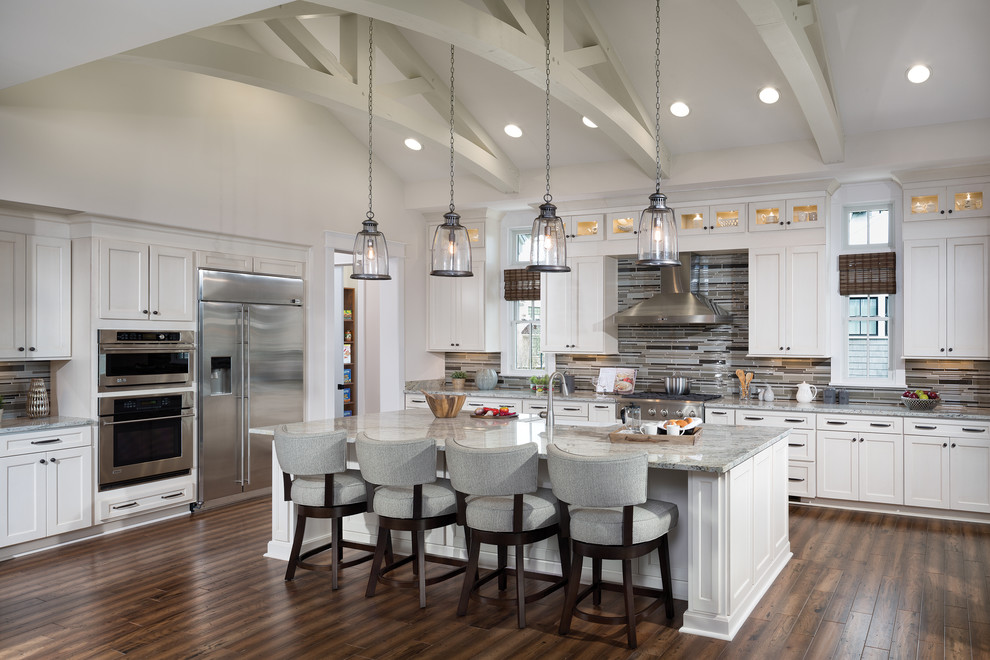 Inspiration for a traditional l-shaped kitchen in Tampa with shaker cabinets, white cabinets, granite benchtops, multi-coloured splashback, matchstick tile splashback, stainless steel appliances, medium hardwood floors and with island.