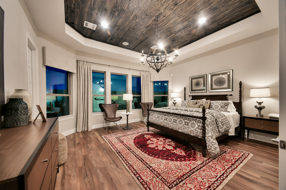 Inspiration for a traditional bedroom in Houston with beige walls, medium hardwood floors and brown floor.